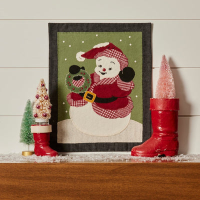 Decorative wall hanging of a snowman in a santa suit and a wreath